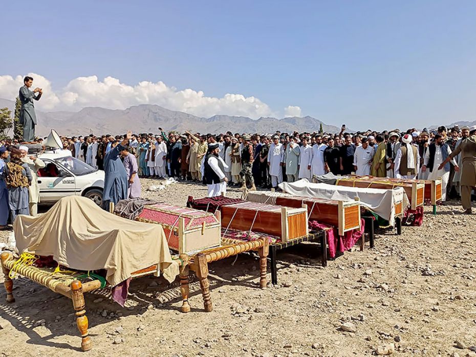 Sunni Muslim men gather to offer prayers during the funeral ceremony for victims who were killed in 