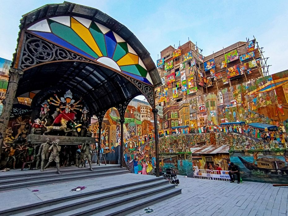 A brilliant stage setting made of a building-high wall of story-telling murals forms the backdrop of