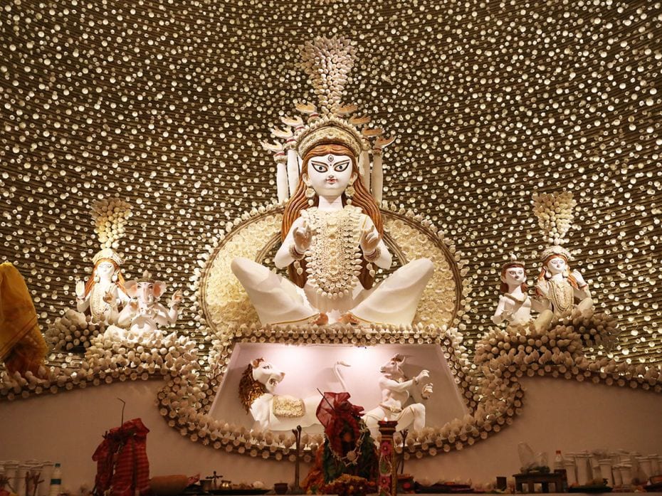 Delicate cream-and-white-hued flower buds and elements mark the presentation of Durga at this pandal