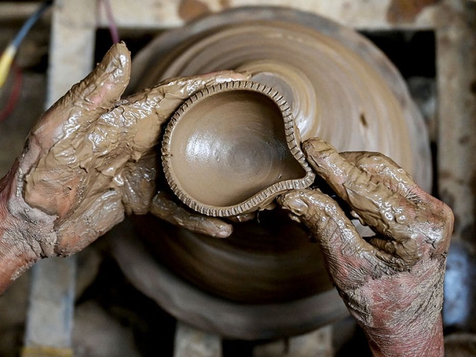 A potter makes a traditional earthen lamp ahead of 'Diwali', the festival of lights, at his workshop