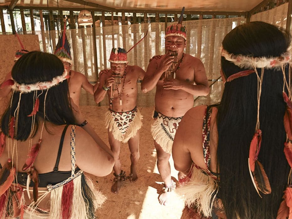 Indigenous men and women from the Colombian Amazon practice a dance at the green zone during the COP