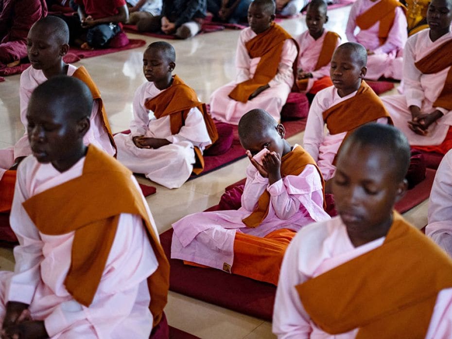 A Ugandan Buddhist novice nun reacts while meditating during the celebration of Kathina, a significa