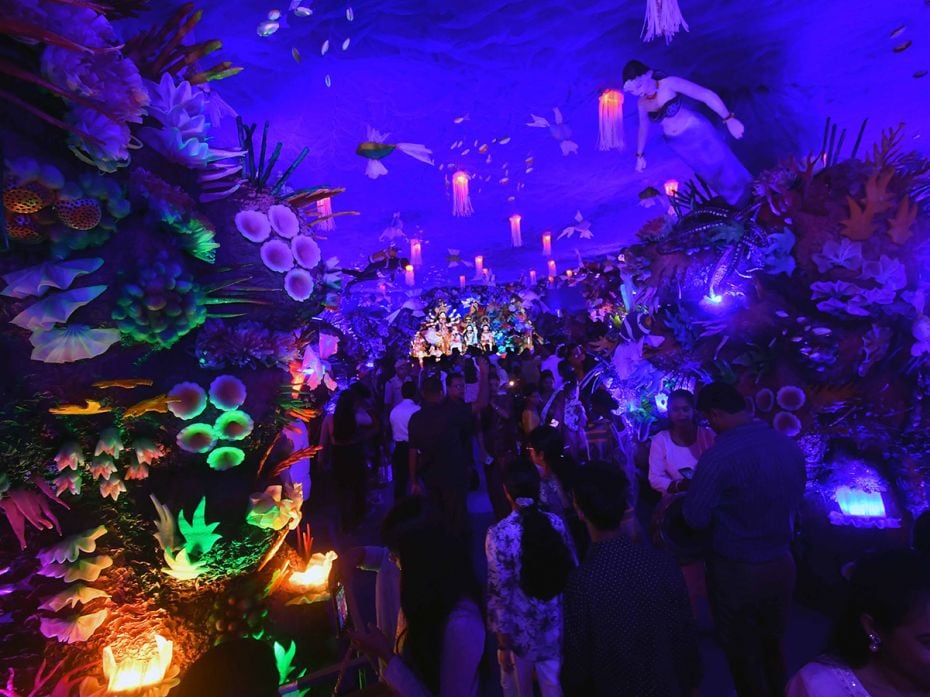 An eerie underwater blue submerges devotees at a puja pandal themed 'under the sea' in Nagaon, 