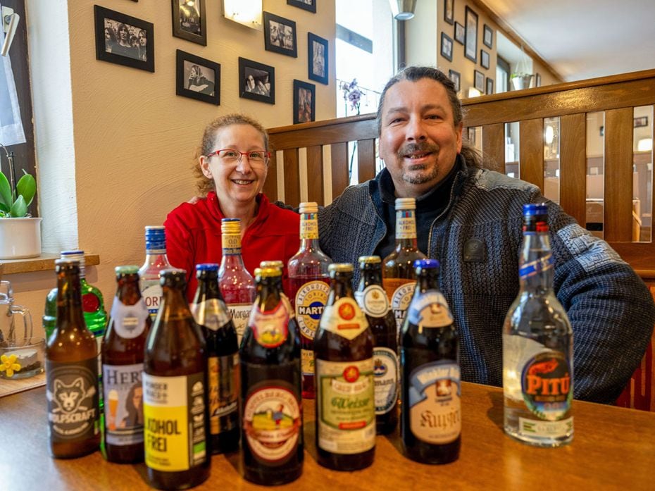 Inn owners Kerstin Goessl and Vladimir Kloz sit behind numerous bottles of non-alcoholic beers and o