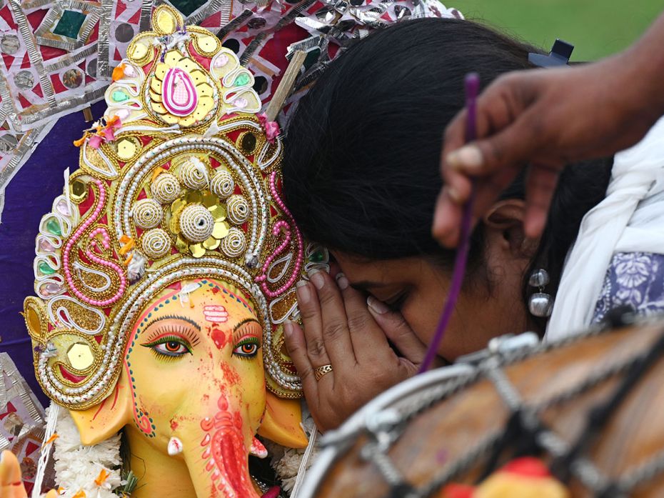 A devotee whispers a fervent prayer to Ganesha before the immersion in Yamuna River near Jaitpur Mad