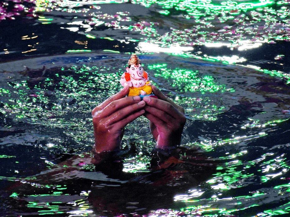 A tiny idol of Ganesh is glimpsed before its immersion in an artificial pond in Mumbai on September 