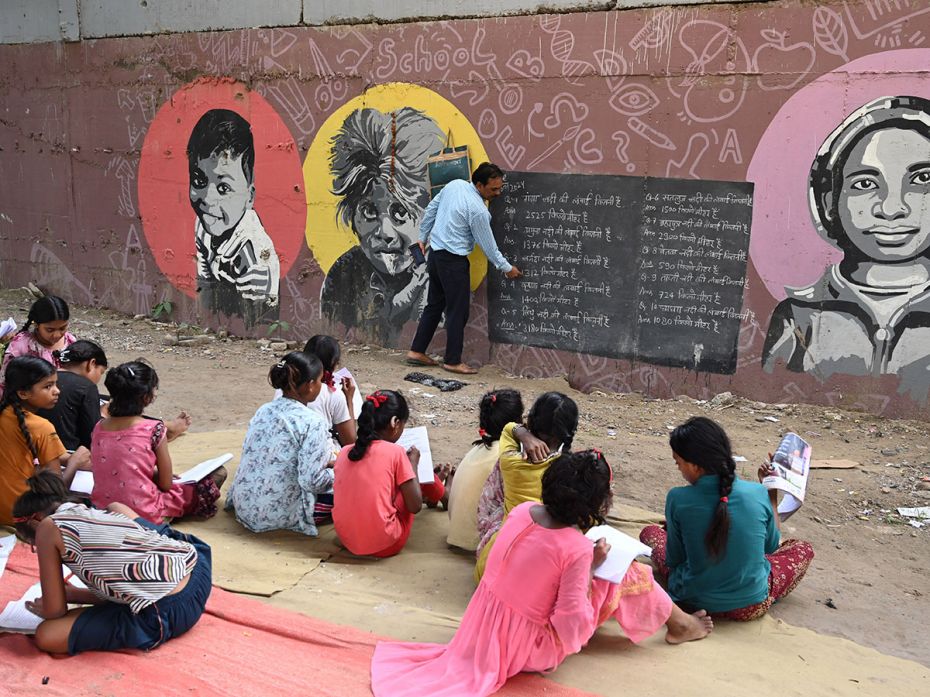 Rajesh Kumar Sharma teaches underprivileged children for free under the Yamuna Bank Metro Station pi