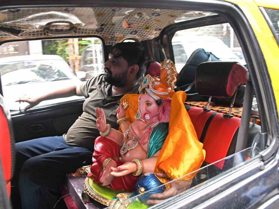 A passenger takes the deity home in a taxi on the eve of the Ganesh Chaturthi festival in Mumbai on 