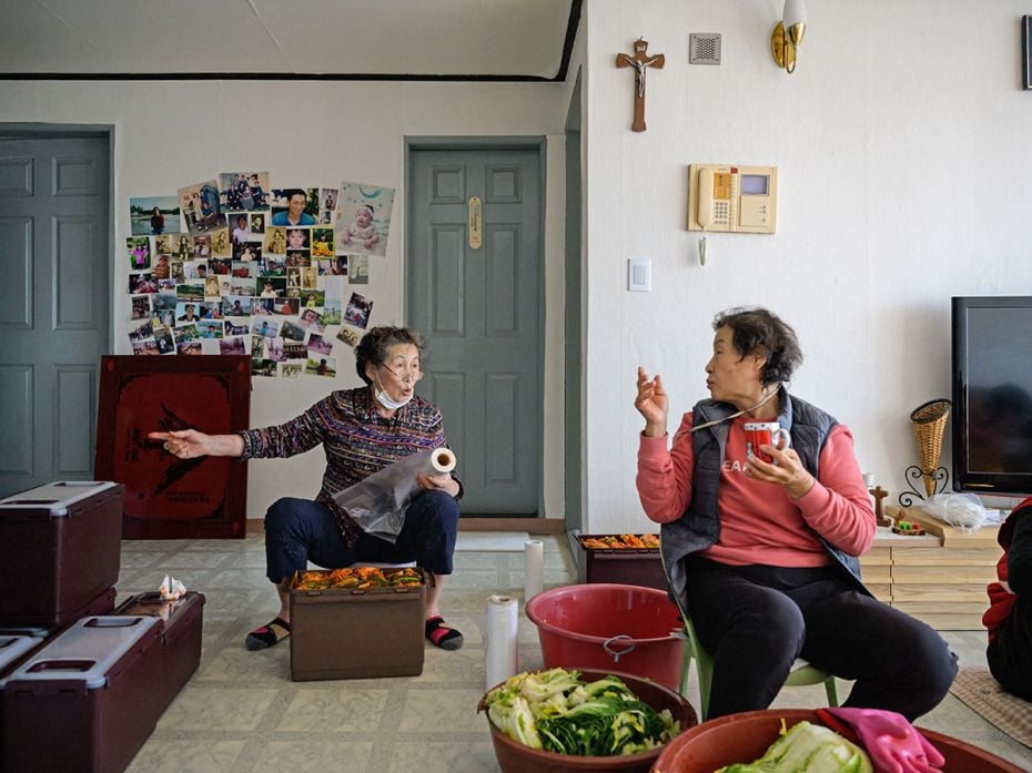 Korean women pack kimchi into Tupperware and other brand containers in a traditional communal proces